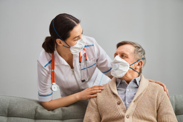 Image of Nurse talking with elderly patient and wearing face masks