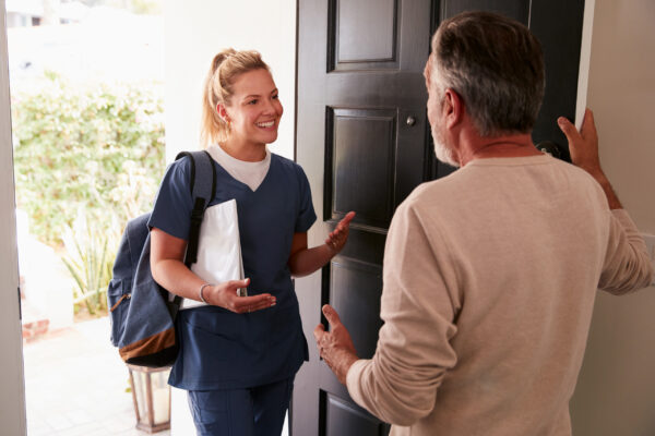 Image of Carer greeting a patient at their house