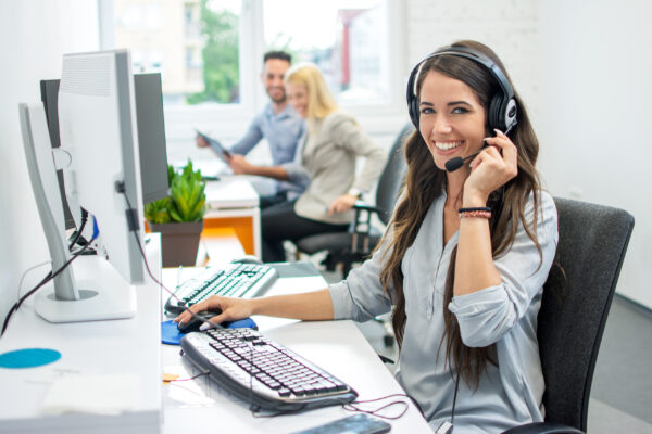 Image of woman working at desk computer with headset