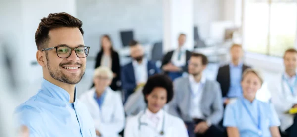 Man with glasses in group looking at camera
