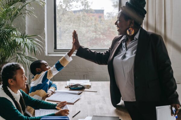 Image of Teacher high-fiving young child